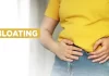 Woman holding stomach in pain, showing signs of persistent bloating