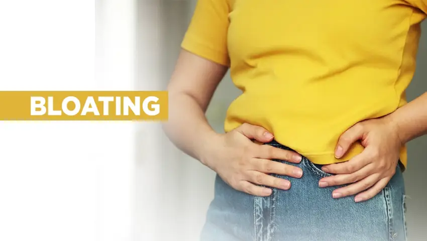 Woman holding stomach in pain, showing signs of persistent bloating